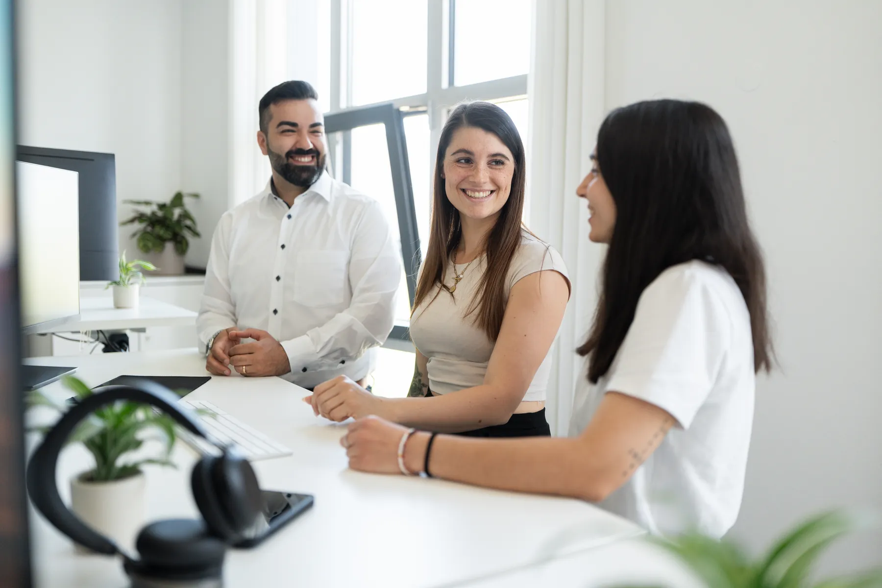 Drei Mitarbeitende von AO Consulting im Gespräch am Arbeitsplatz in Bruchsal