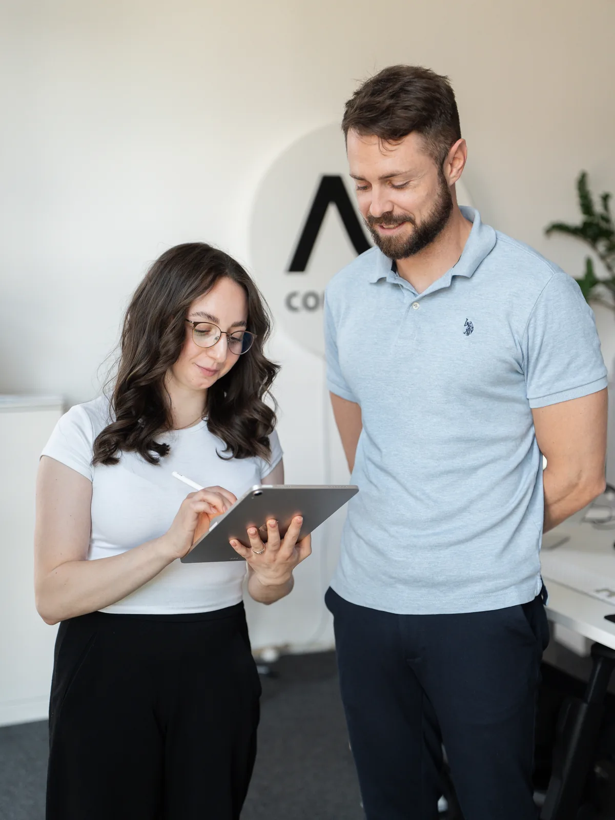 Zwei Mitarbeitende von AO Consulting planen am Tablet den Auftritt einer neuen Praxis