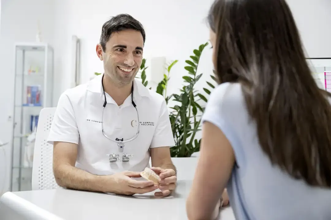 Zahnarzt im Beratungsgespräch mit einer Patientin