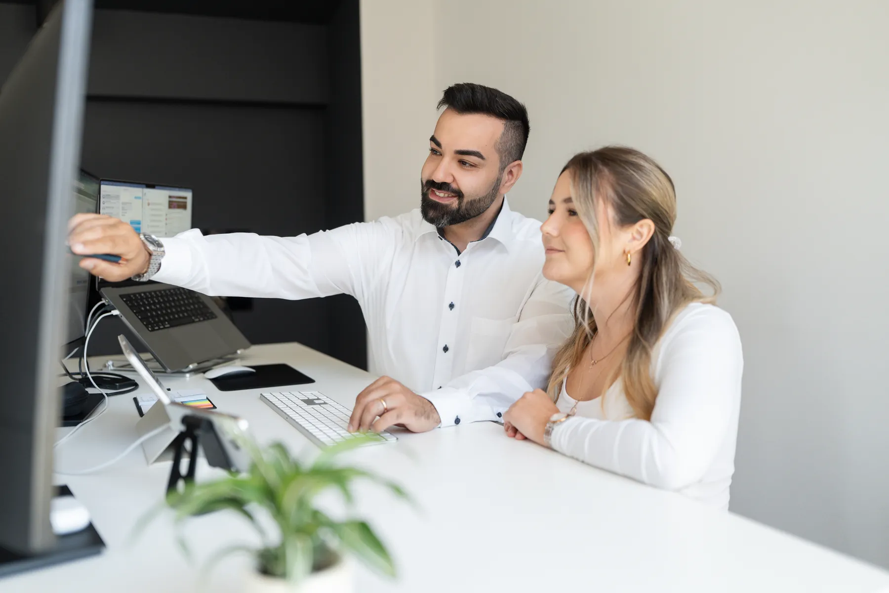 Zwei Mitarbeitende von AO Consulting gehen am Bildschirm ein Karriereportal durch